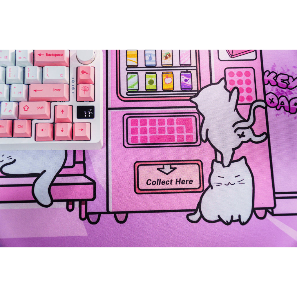 A pink deskmat featuring cat with a white keyboard