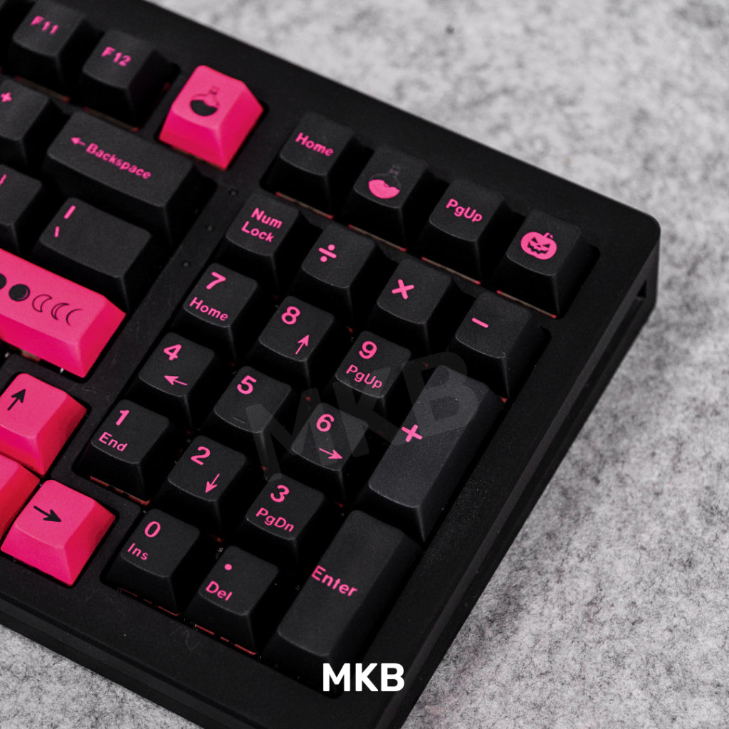 Black and pink keycaps on keyboard, showing numpad keys and pumpkin icon on the keycap