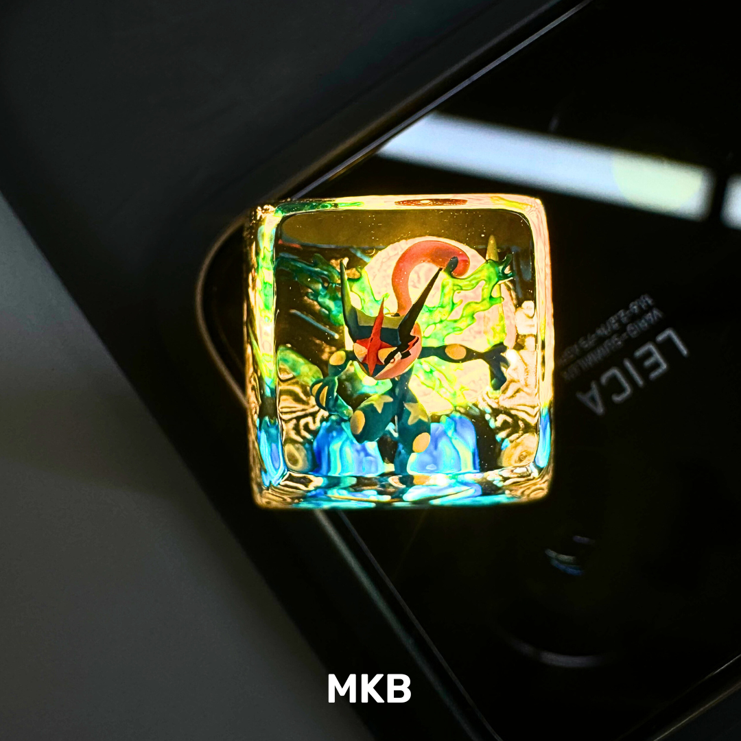Ash Greninja artisan keycap sitting on a backlit keyboard, showcasing its shine-through effect for an enhanced RGB glow.